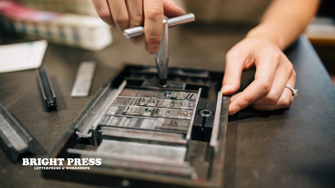 Metal type being locked up in a printing chase 