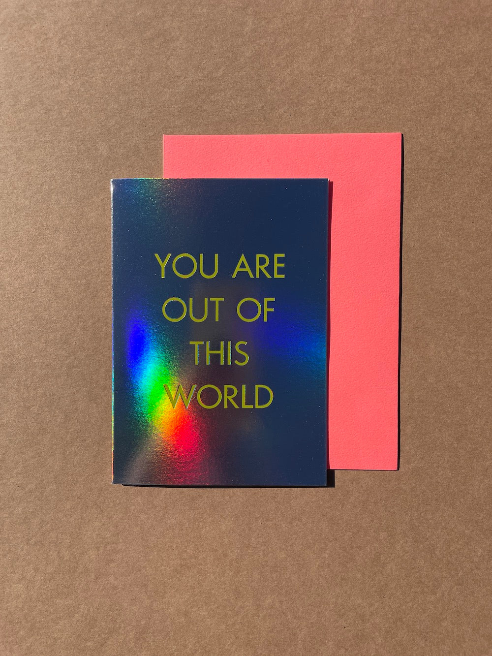 You Are Out Of This World card with text reading "You are out of this world" printed on mega shiny card. The card is so shiny that you can see Ann's arm reflected in the shiny card.