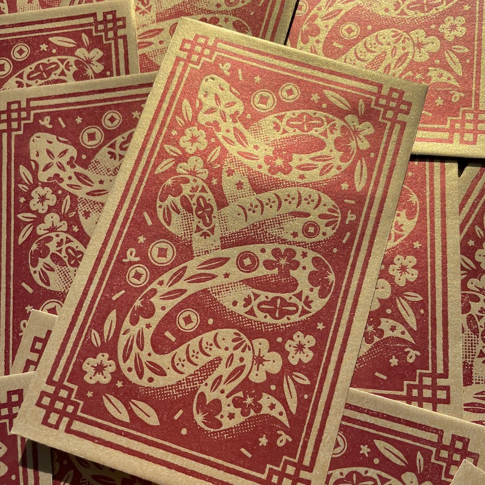 Close up of a Year of the Snake Red Packet featuring the gold snake and the red background.